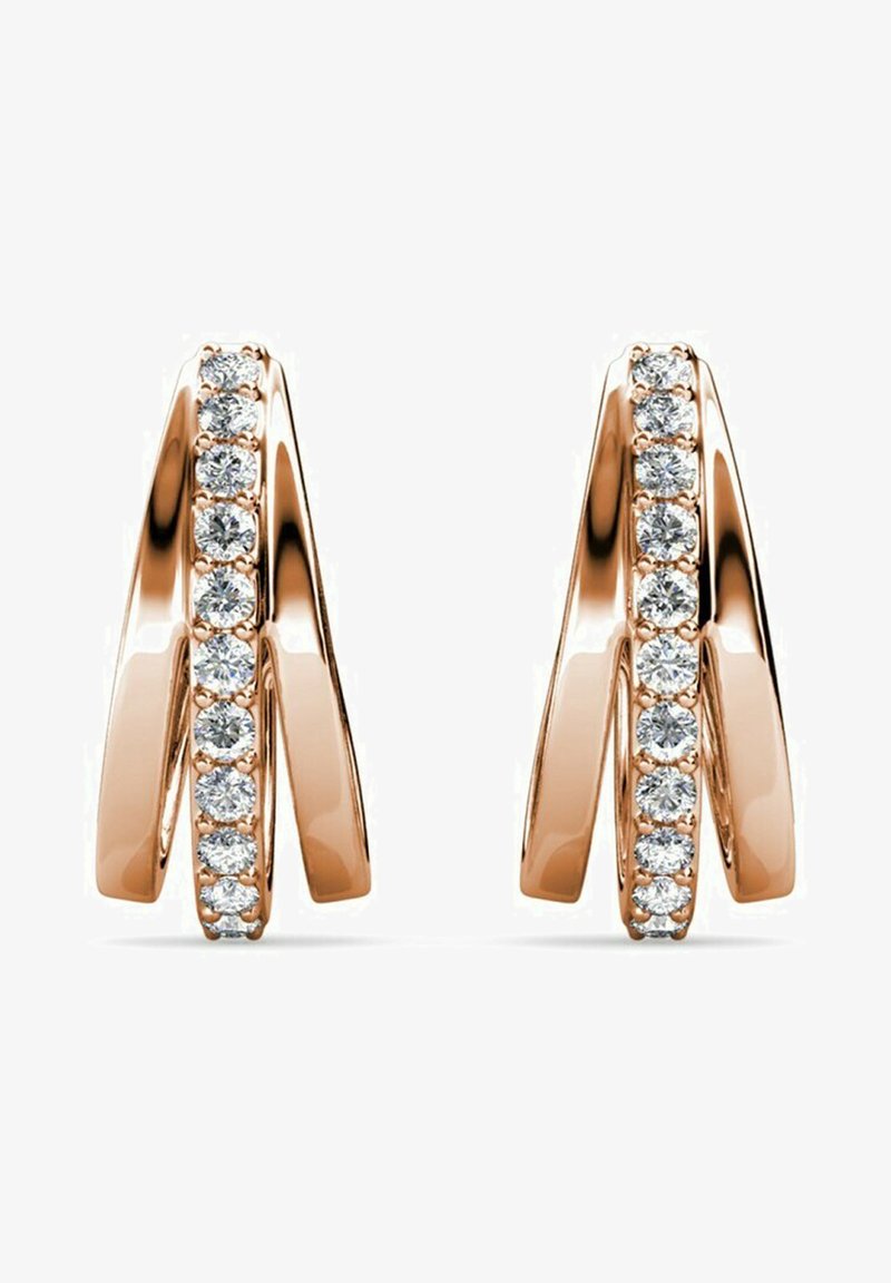 Orecchini in oro rosa con un design fluido caratterizzato da forme intrecciate e una fila di pietre trasparenti rotonde alternate lungo un bordo.