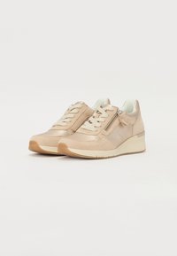 Sneaker beige in pelle con tomaia texture, chiusura con lacci, zip laterale e tacco a cuneo. Suola in gomma con un leggero motivo antiscivolo.