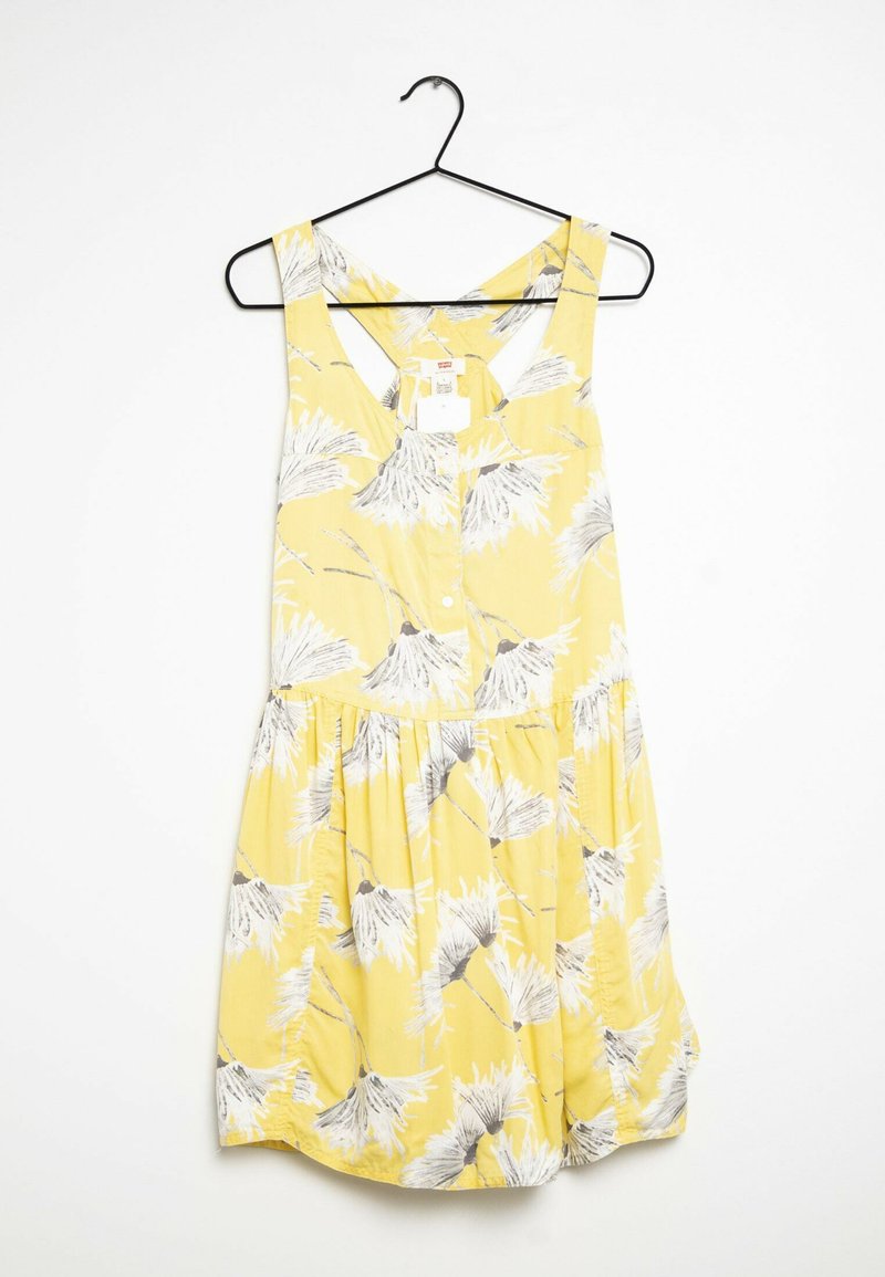 Gul ärmlös klänning med blommönster i grått och vitt, med knäppning fram, samlad midja och en utsvängd kjoldesign.