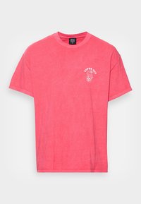 Korallrosa kortärmad t-shirt med liten vit text "Viper Pit" och orm-grafik på vänster bröst, rund halsringning och BDG-märkesetikett inuti kragen.