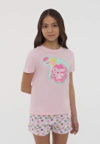 T-shirt in cotone rosa chiaro con un colorato logo "Chupa Chups" e lecca-lecca. Abbinate a pantaloni corti bianchi decorati con motivi di caramelle.