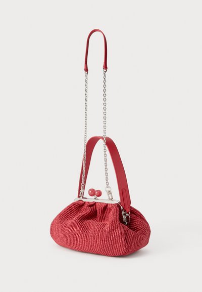 Κόκκινο τσαντάκι χειρός με υφή και στρογγυλό κούμπωμα, με κοντή δερμάτινη λαβή και μακρύ ασημένιο αλυσίδα λουράκι σε λευκό φόντο.