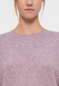 Sweater lilás tricotado com um design de tranças, gola redonda e tecido texturizado. Material suave e leve com uma aparência aconchegante.