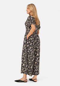 Zwart en beige gemêleerde maxi-jurk met korte mouwen, zijzakken en een comfortabele pasvorm. Draag met platte zwarte schoenen.