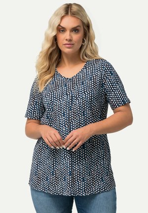 Top blu e bianco a pois con scollo a V e maniche corte, realizzato in tessuto morbido, caratterizzato da dettagli a pieghe sulla parte toracica.