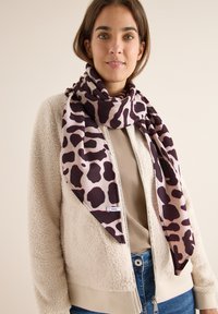 Let scarf i beige med mørkebrunt dyreprint. Lavet af blødt stof, med et distinkt mønster og et mærke mærket "CEZIL."