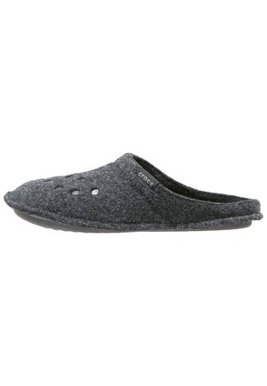 Chausson gris foncé à enfiler avec une tige en tissu doux, de petits trous de ventilation près des orteils et une étiquette logo Crocs sur le côté.