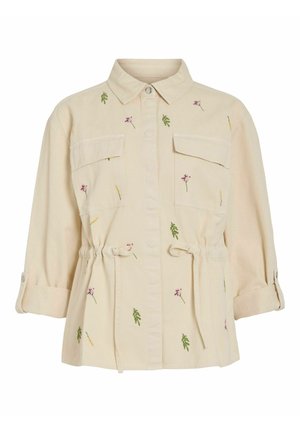 Béžová bunda na zapínanie na gombíky s golierom, dvoma náprsníkovými vreckami, opaskami v páse, vyhrnutými rukávmi a malými vyšívanými zelenými listami a ružovými kvetmi.