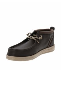 Stivaletto in pelle marrone con finitura liscia, punta rotonda e suola in gomma beige. Presenta dettagli decorativi in metallo nei lacci.
