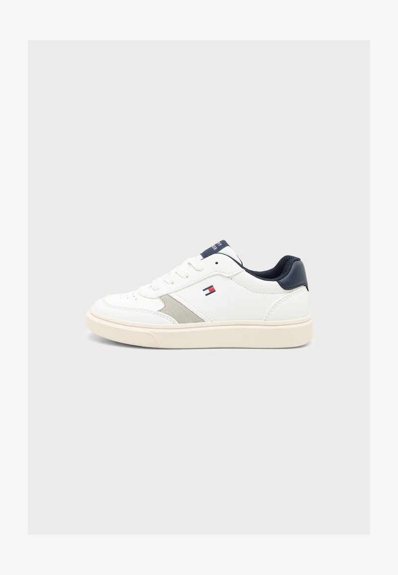 Λευκό low-top αθλητικό παπούτσι με ναυτικό μπλε λεπτομέρειες, μπεζ σόλα, κορδόνια και μικρό κόκκινο, λευκό και μπλε λογότυπο στην πλευρά.