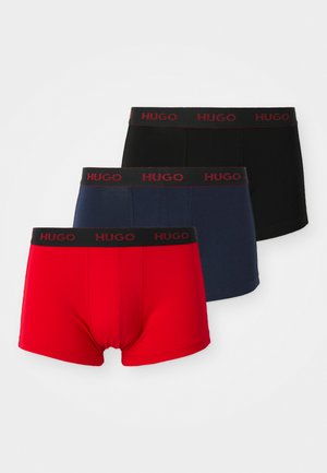 Tres pares de bóxer para hombre de Hugo en rojo, azul marino y negro. Cada uno presenta una cintura negra con la palabra "HUGO" en letras rojas. Tejido suave.