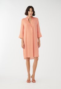 Kurzes Oberteil, knielanges Kleid aus leichtem Stoff mit geometrischem orange-weißen Muster, Kragen und lässiger Passform.
