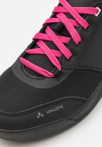 Chaussure de sport noire avec des lacets roses, une tige texturée et une semelle en caoutchouc. Logo "Vaude" sur le côté, design élégant pour une utilisation en extérieur.