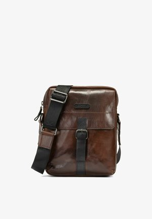 Brązowa skórzana torba na ramię z czarnym regulowanym paskiem, detalem z przodu na klamrę oraz nazwą marki "OCHNIK" na klapie.