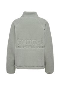 Polarowy pulower w jasnym zielonym kolorze, z wysokim kołnierzem, wyszywanym logo "hummel PERFORMANCE" oraz teksturowanym, miękkim materiałem.