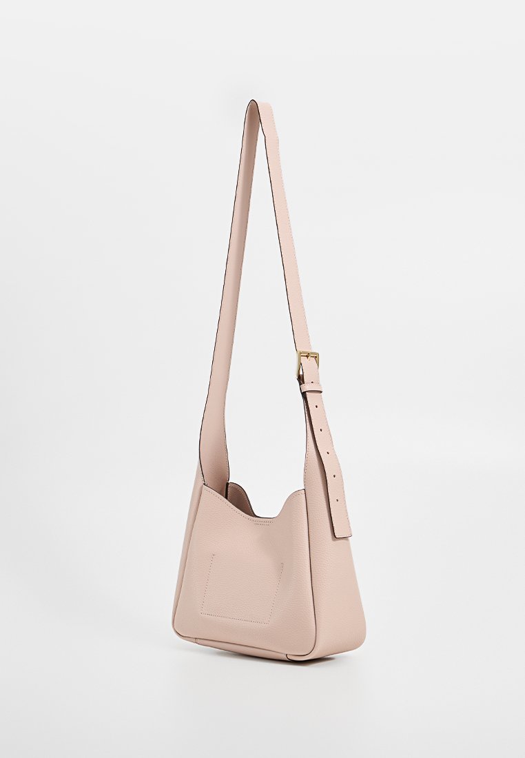 Sac à épaule en cuir rose, de forme courbée, avec une bandoulière réglable et un subtil accent carré à l'avant. Texture lisse, design minimaliste.