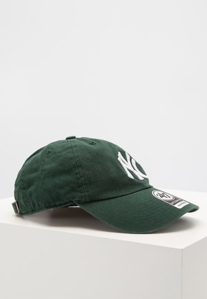 Green cotton baseball cap with white embroidered "NY" logo, curved peak, adjustable strap at the back, and side label detail.