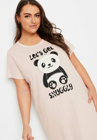 Camicia da pigiama rosa con una grafica di panda in bianco e nero e il testo "Mettiamoci Comodi". Tessuto morbido, maniche corte, vestibilità comoda.