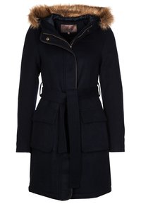 Manteau en mélange de laine bleu marine avec une capuche en fausse fourrure, fermeture éclair à l'avant, ceinture à la taille et deux grandes poches à rabat.