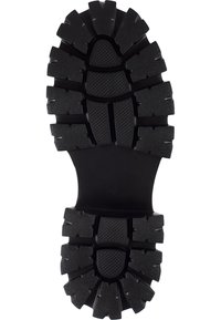 Semelle de chaussure noire en caoutchouc avec des motifs de crampons profonds pour l'adhérence, dotée de crampons prononcés et de zones texturées pour une meilleure prise.