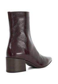 Burgundy leather ankle boot with a tapered toe and a low block heel, featuring a smooth finish and subtle texture.