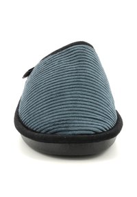 Zapatilla gris sin cordones con textura acanalada, ribete negro y diseño de punta curva. Suela lisa y flexible para mayor comodidad.