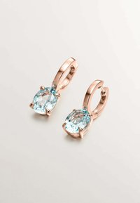 Pendientes de oro rosado con piedras preciosas ovaladas de un suave color azul claro, sujetas por cuatro garras, con una superficie lisa y pulida y pequeñas piedras de acento.