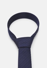 Marineblå slips med stripet mønster, laget av glatt stoff. Den har en ferdig-knyttet knute og en klassisk form.