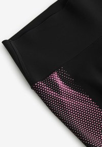 Svarta träningsleggings med en slät yta, med en gradient av rosa prickiga mönster längs ena sidan. Platta sömmar och elastisk midja.