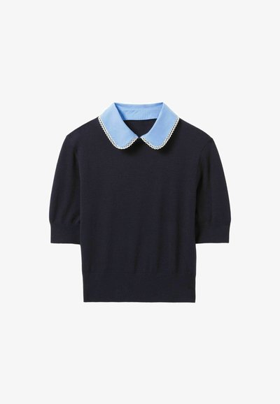 Top de punto navy con mangas cortas, que presenta un collar redondeado de color azul claro con borde de encaje. Diseño simple, textura suave, estilo ajustado.