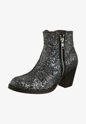 Bottine noire couverte de paillettes argentées avec fermeture éclair latérale et talon block, inclinée pour montrer le côté extérieur et la semelle.