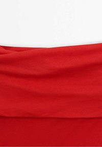 Tissu extensible rouge avec une texture douce, présentant un design froncé à la taille et une finition lisse sur l'ensemble du vêtement.