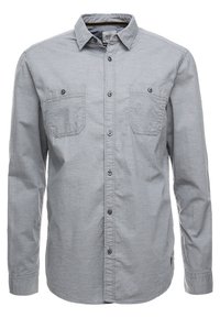 Chemise à manches longues en tissu gris clair, dotée d'un col à boutons, de deux poches poitrine et de boutons sur le devant. Texture douce et design décontracté.