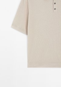 Beige kortærmet polo med ribbet struktur, tre-knaps lukning og lige kant.