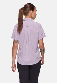 Camisa de cuadros morados de manga corta con cuello abotonado, que presenta un pliegue en la espalda y un sutil detalle en forma de bucle cerca del cuello.