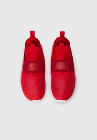 Rote Nike-Sneaker mit einem strukturierten Obermaterial, elastischem Riemen und einer Zuglasche an der Ferse. Mit einer kontrastierenden weißen Sohle.