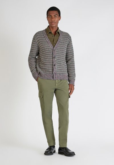 Szary i purpurowy sweter w wzory z guzikami, połączony z oliwkowymi spodniami cargo i czarnymi mokasynami. Prosty, codzienny design.