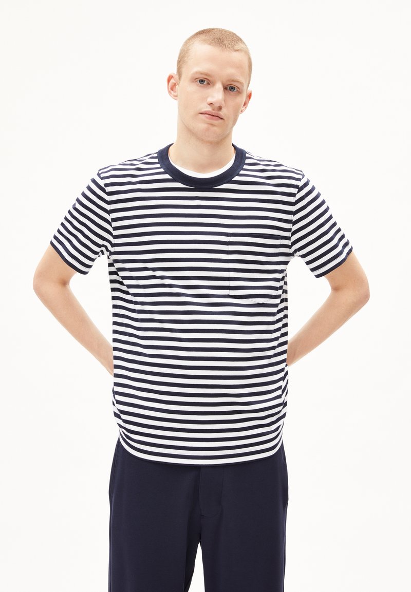 T-shirt a righe blu navy e bianche a maniche corte con collo rotondo e una singola tasca sul petto, realizzata in un tessuto morbido e liscio.