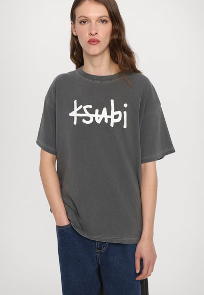 Camiseta de algodón gris de gran tamaño con un estampado gráfico en blanco que dice "ksubi". Presenta mangas cortas y un cuello redondo.