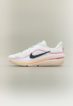 Pantof sport alb și roz Nike, cu swoosh negru, partea superioară din plasă respirabilă și talpă groasă cu amortizare, inscripționată cu "ComfiRide" și "Air."