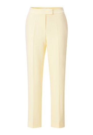 Kreemja kollase tooniga sihitud sirge säärega püksid varjatud esikinnitusega ja triigitud kortsudega valgel taustal.