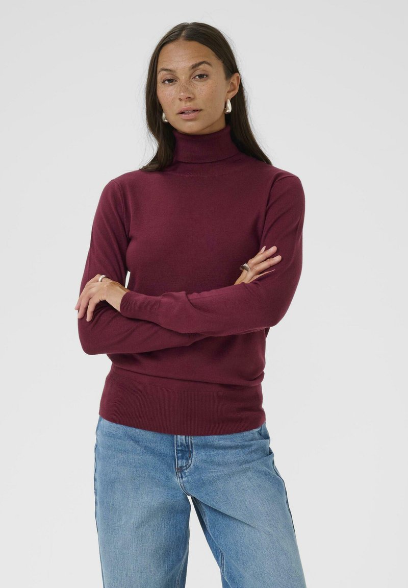 Burgundy-coloured kauluspusero valmistettu pehmeästä kankaasta, jossa on pitkät hihat ja joustavat hihansuut sekä helma, yhdistettynä vaaleansinisiin farkkuihin.