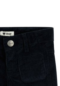 Dunkelmarineblaue Cordhose aus strukturiertem Stoff, mit Knopfverschluss und einer Vordertasche. Enthält ein Markenetikett mit Bärenlogo.