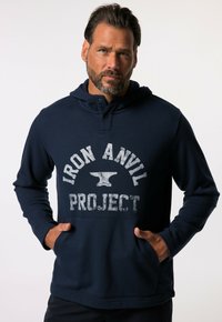 Sudadera de color azul marino hecha de una tela suave, que presenta una gran impresión gráfica gris de un yunque y el texto "IRON ANVIL PROJECT". Incluye bolsillos.
