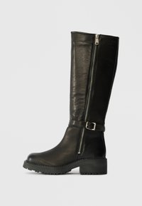 Schwarze Leder-Knöchelhohe Stiefel mit einem seitlichen Reißverschluss, Schnallenakzent und dicker Sohle. Merkmale sind eine glatte Textur und eine robuste Verarbeitung.