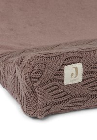 Couverture en tricot pour bébé de couleur rose poussiéreux, présentant un motif texturé sur les bords et une petite étiquette avec le nom de la marque "Jollein."