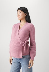 Rosa stickad omslagströja med långa ärmar och knytning på sidan. Har en ribbad textur och en djup urringning.