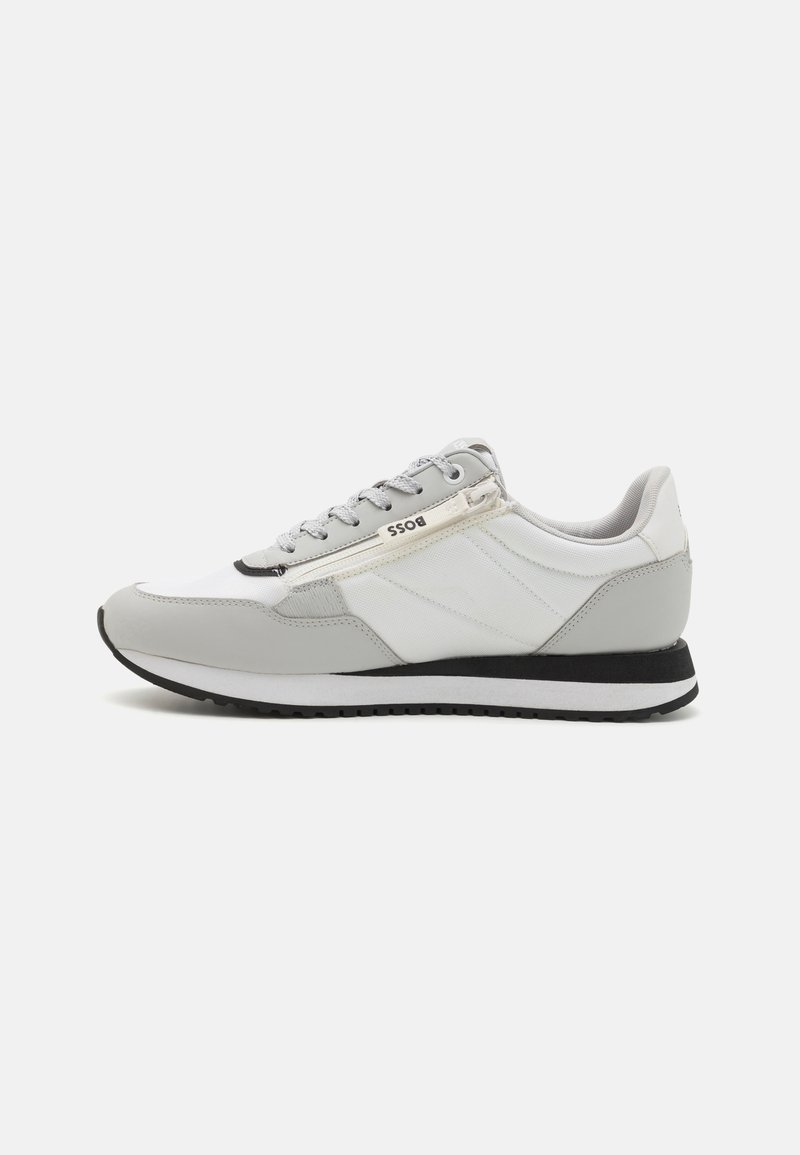 Sneaker sintetico e in tessuto grigio con intersuola bianca, suola nera e branding sobrio. Caratterizzato da un design con lacci e pannelli testurizzati.
