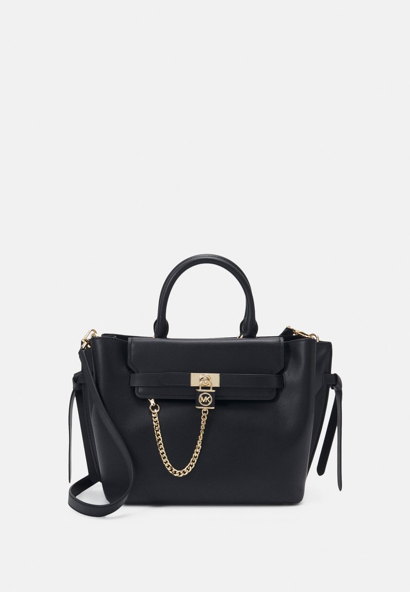Borsa a tracolla in pelle nera con hardware dorato, forma rettangolare, due manici superiori e una tracolla rimovibile. Presenta un dettaglio a catena e una chiusura a morsetto.