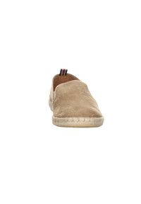 Zapato tipo slip-on beige con una superficie texturizada, suela de yute tejido y un acento de rayas negra, roja y blanca en la parte trasera.